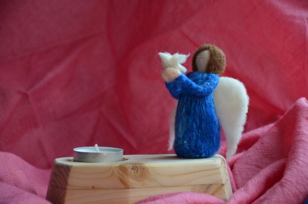Handgefilzte Friedenstaube mit einer kleinen Figur